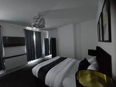 a bedroom with a bed and a table and windows at Lily in Blackpool