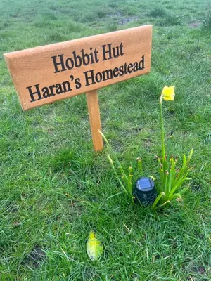 a sign that says hochrichhoff hamanns homestead in the grass at Off GRID Hobbit Hut with Wood Burning Hot tub NO SHOWER in Hapton