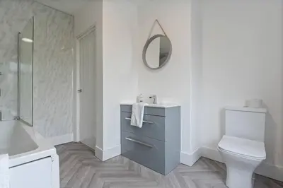 a bathroom with a toilet and a sink and a mirror at Beautiful House - Sleeps up to 7 - Free Parking, Fast Wifi and Smart TV by Yoko Property in Wigan