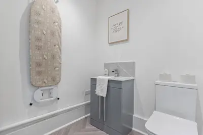 a white bathroom with a sink and a toilet at Beautiful House - Sleeps up to 7 - Free Parking, Fast Wifi and Smart TV by Yoko Property in Wigan