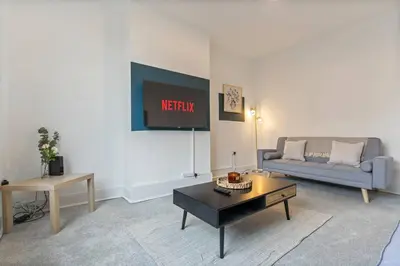 a living room with a couch and a table at Beautiful House - Sleeps up to 7 - Free Parking, Fast Wifi and Smart TV by Yoko Property in Wigan