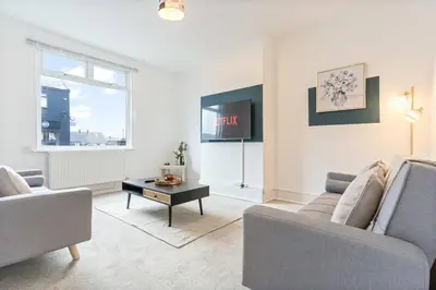 a living room with two couches and a tv at Beautiful House - Sleeps up to 7 - Free Parking, Fast Wifi and Smart TV by Yoko Property in Wigan