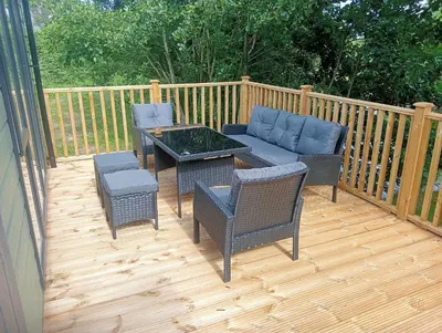 a patio with a couch and chairs on a deck at Lake View Lodge in Lytham St Annes