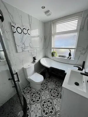 a white bathroom with a toilet and a sink at Beachside Suites - HOT TUB sleeps 10 in Blackpool