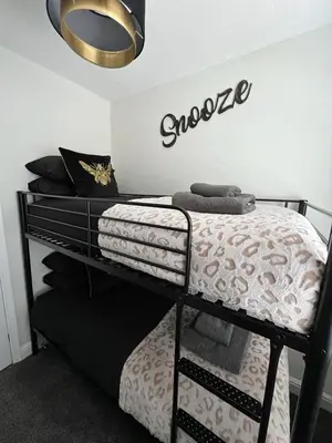 a bedroom with a bunk bed with a sign on the wall at Beachside Suites - HOT TUB sleeps 10 in Blackpool
