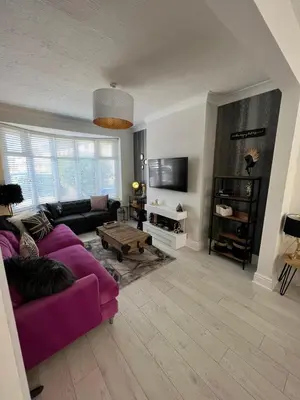 a living room with a purple couch and a tv at Beachside Suites - HOT TUB sleeps 10 in Blackpool