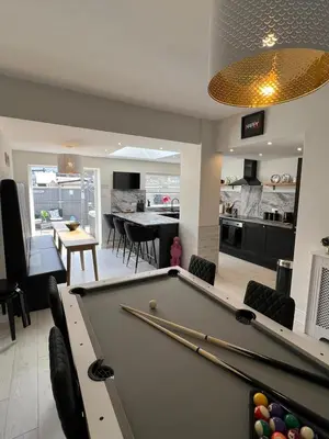 a living room with a pool table and a kitchen at Beachside Suites - HOT TUB sleeps 10 in Blackpool