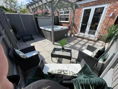 an outdoor patio with chairs and a hot tub at Beachside Suites - HOT TUB sleeps 10 in Blackpool