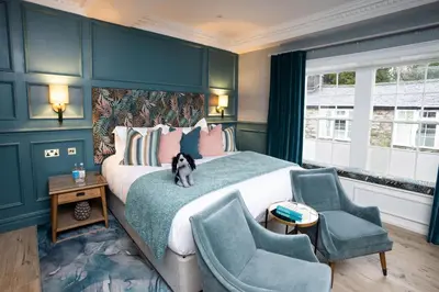 a bedroom with a large bed with a cat sitting on it at Aynsome Manor in Cartmel