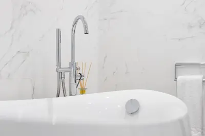 a white bathroom with a sink and a faucet at Aynsome Manor in Cartmel