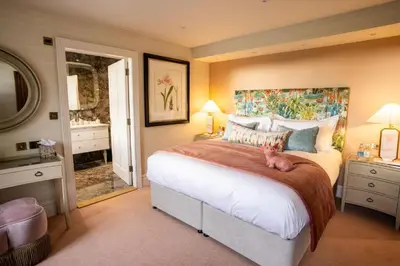 a bedroom with a large bed with a cat laying on it at Aynsome Manor in Cartmel