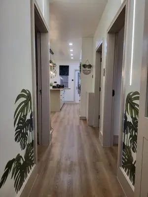a hallway with white walls and wooden floors and a kitchen at Country Style Modern Self Catering 3 Bedroom Bungalow in Blackpool in Blackpool