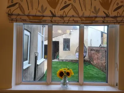 a window with a vase of flowers on a window sill at Country Style Modern Self Catering 3 Bedroom Bungalow in Blackpool in Blackpool