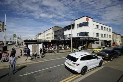 a white car parked on the side of a city street at Haven Heights International in Blackpool