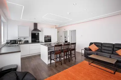 a kitchen and living room with a couch and a table at Haven Heights International in Blackpool