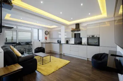 a kitchen and living room with white cabinets at Haven Heights International in Blackpool