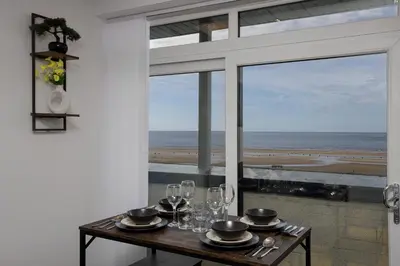 a table with wine glasses and a view of the ocean at Haven Heights International in Blackpool