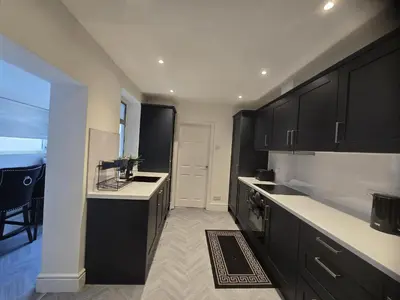 a kitchen with black cabinets and a white counter top at Seaside Retreat on Fleet Street in Blackpool