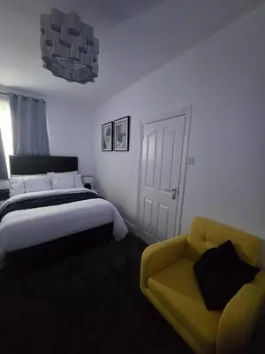a bedroom with a bed and a yellow couch at Seaside Retreat on Fleet Street in Blackpool
