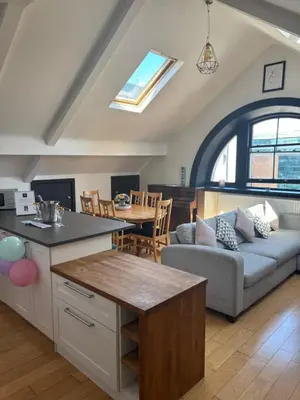 a kitchen and living room with a couch and a table at 2 Bedroom City Centre Penthouse Loft Apartment in Liverpool