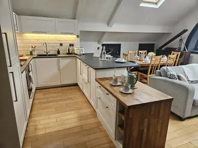 a kitchen and living room with a table in it at 2 Bedroom City Centre Penthouse Loft Apartment in Liverpool