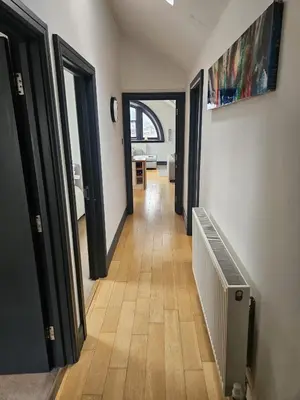 a hallway with doors and a wooden floor at 2 Bedroom City Centre Penthouse Loft Apartment in Liverpool