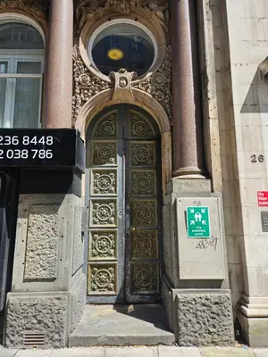 a gold door on a building with a sign on it at 2 Bedroom City Centre Penthouse Loft Apartment in Liverpool