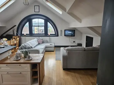 a living room with a couch and a table at 2 Bedroom City Centre Penthouse Loft Apartment in Liverpool