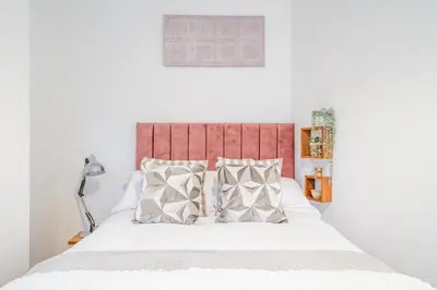 a bedroom with a bed with a red headboard and pillows at Fabulous New 1 Bedroom Ground Floor Flat in Morecambe