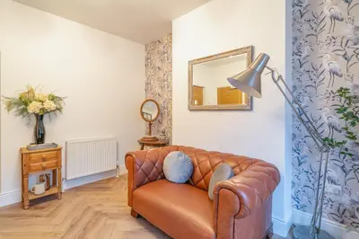 a living room with a leather couch and a mirror at Fabulous New 1 Bedroom Ground Floor Flat in Morecambe