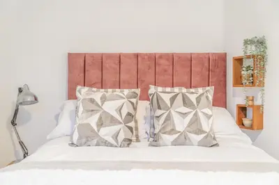 a bedroom with a bed with white sheets and pillows at Fabulous New 1 Bedroom Ground Floor Flat in Morecambe