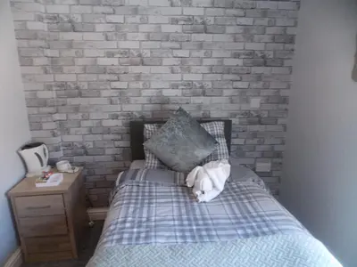 a bed with a teddy bear laying on it at The Celtic Pride Hotel in Blackpool