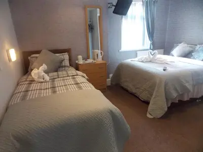 a bedroom with two beds and a teddy bear on the bed at The Celtic Pride Hotel in Blackpool