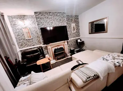 a living room with a couch and a tv at Boxroom SB Hatfield RD in Bolton