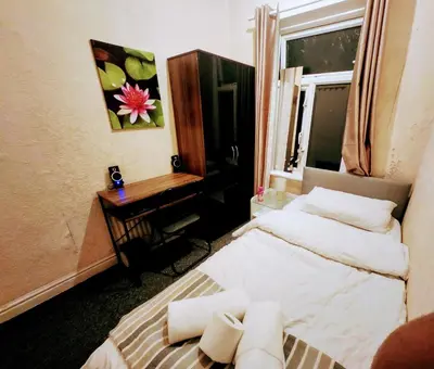 a bedroom with a bed and a desk and a window at Boxroom SB Hatfield RD in Bolton