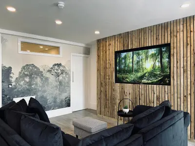 a living room with a couch and a television on a wall at Williamson Suites - Apartment 1 in Liverpool