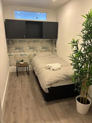 a bedroom with a large bed and a plant at Williamson Suites - Apartment 1 in Liverpool