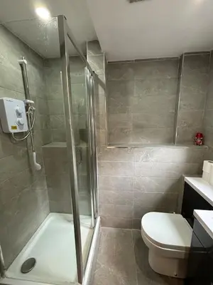 a bathroom with a shower and a toilet and a sink at Williamson Suites - Apartment 1 in Liverpool