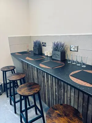a bar with wooden stools at a counter in a restaurant at Williamson Suites - Apartment 1 in Liverpool