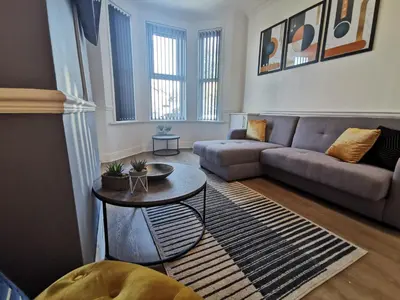 a living room with a couch and a table at Comfy and Cozy 3 Bed house, free parking & Wifi in Birkenhead