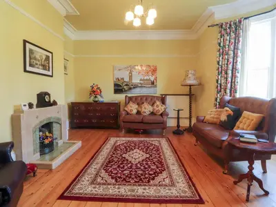 a living room with a couch and a fireplace at Mullans in Southport