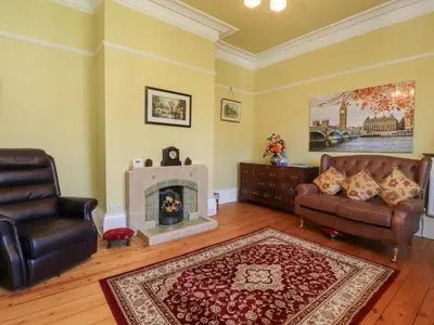 a living room with a couch and a fireplace at Mullans in Southport