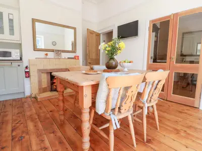 a dining room with a wooden table and chairs at Mullans in Southport
