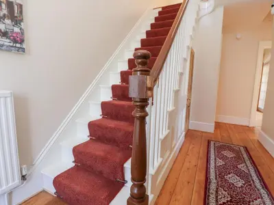 a staircase in a home with red carpet at Mullans in Southport