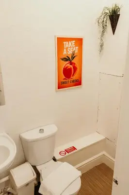 a bathroom with a toilet and a poster on the wall at Glen Allan Hotel in Blackpool