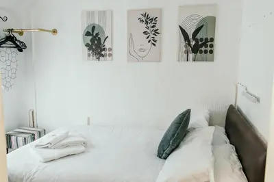 a bed in a bedroom with four pictures on the wall at Glen Allan Hotel in Blackpool