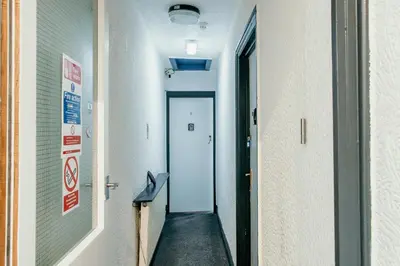 a hallway in a hospital with a door leading to a room at Glen Allan Hotel in Blackpool