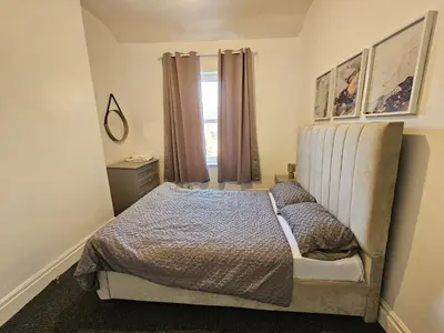 a bedroom with a bed and a window at Convenient 3 bed, Pr1 near Uclan n Train station in Preston