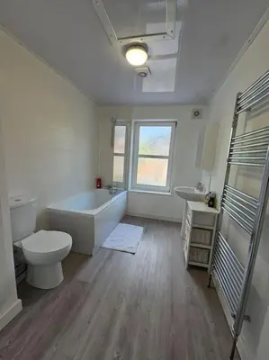a bathroom with a tub and a toilet and a sink at Convenient 3 bed, Pr1 near Uclan n Train station in Preston