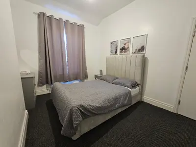 a small bedroom with a bed and a window at Convenient 3 bed, Pr1 near Uclan n Train station in Preston
